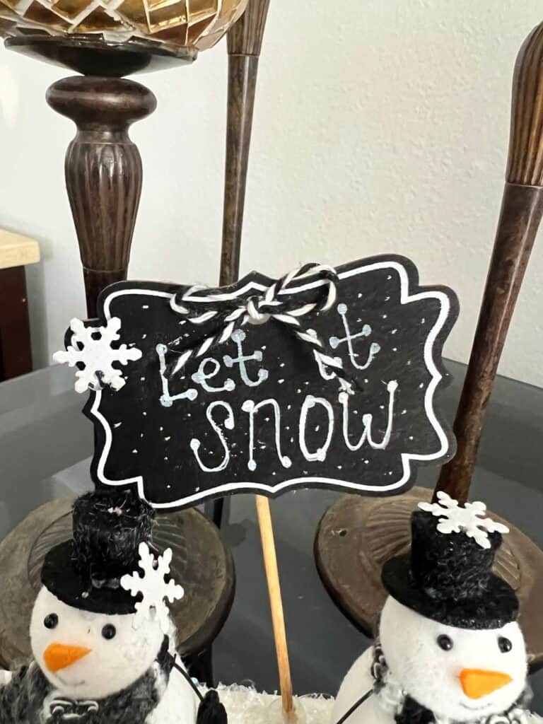 Let it snow written on the chalkboard sign with a snowflake embellishment and bakers twine bow.