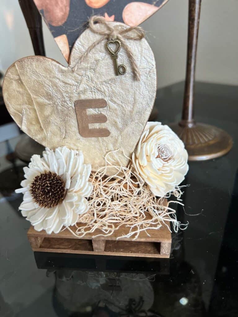 Sola wood flowers and excelsior at the bottom of the stacked hearts.