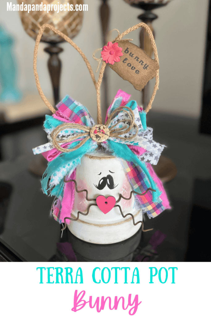 White Terra Cotta Pot Bunny with wired jute ears, a pink, purple, and teal messy fabric bow and a cute tag on her ear that says "bunny love" for spring and easter crafts and decor. 