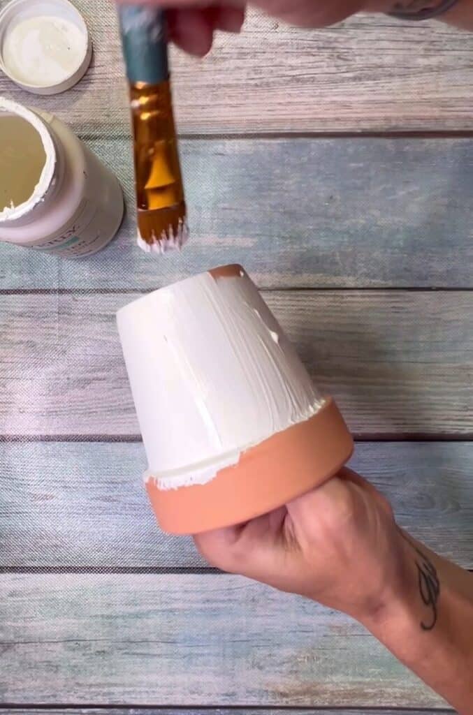 Painting the terra cotta pot white.