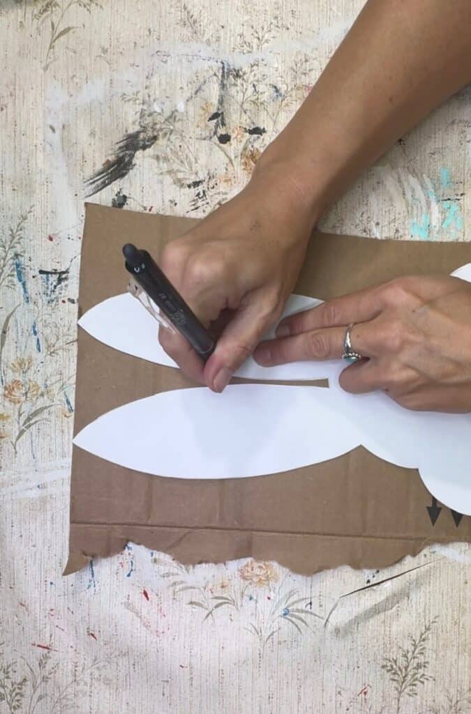 Tracing the bunny template onto the corrugated cardboard.