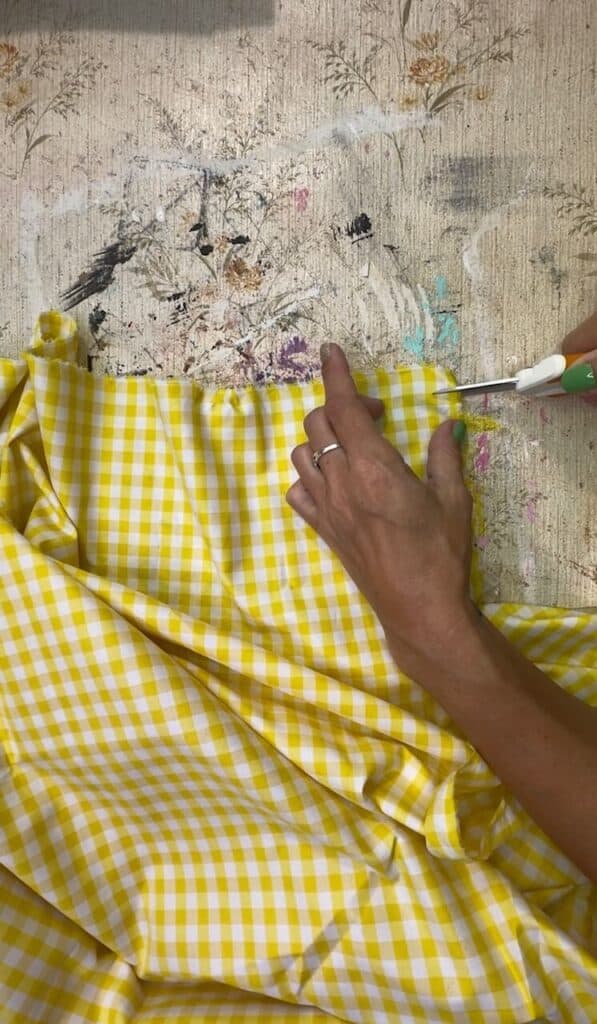 Yellow gingham fabric about to be ripped into strips.