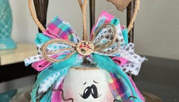 White Terra Cotta Pot Bunny with wired jute ears, a pink, purple, and teal messy fabric bow and a cute tag on her ear that says "bunny love" for spring and easter crafts and decor.