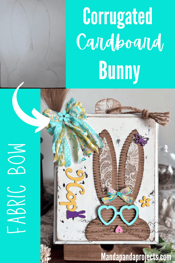 Corrugated cardboard bunny with messy fabric bow with purple, teal and yellow, with teal heart shaped glasses, a heart nose, butterflies, flowers, and a Dollar Tree bunny Hop sign, on a chippy white background.