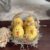 Wood easter eggs made into cute lil yellow peeps chicks in a recycled egg carton with spanish moss and a tag that says "Chicks .10 c" and a jute rope handle.