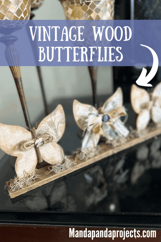 3 Wood Butterfly shelf sitter with a vintage vibe with a spring hangtag and twine and fabric bows, sitting on a base with spanish moss.