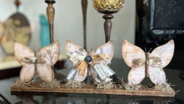 3 Wood Butterfly shelf sitter with a vintage vibe with a spring hangtag and twine and fabric bows, sitting on a base with spanish moss.