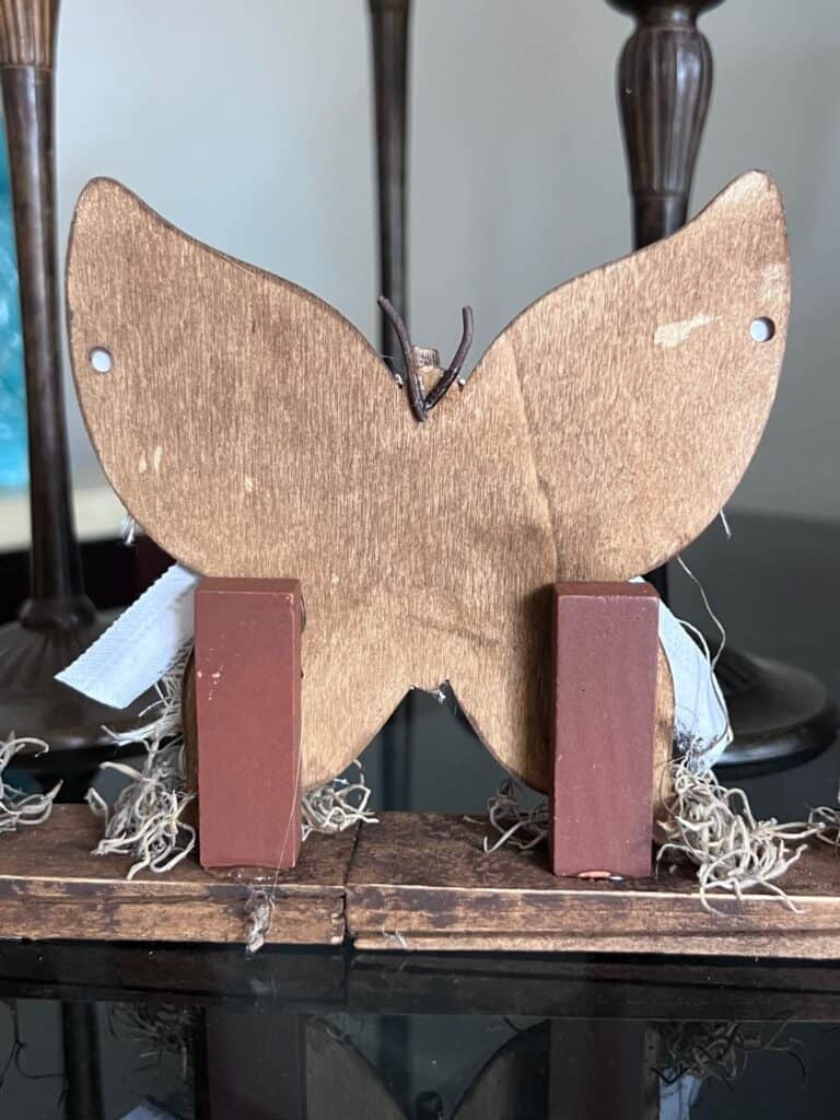 Back of the wood butterfly showing the Jenga blocks holding it up.