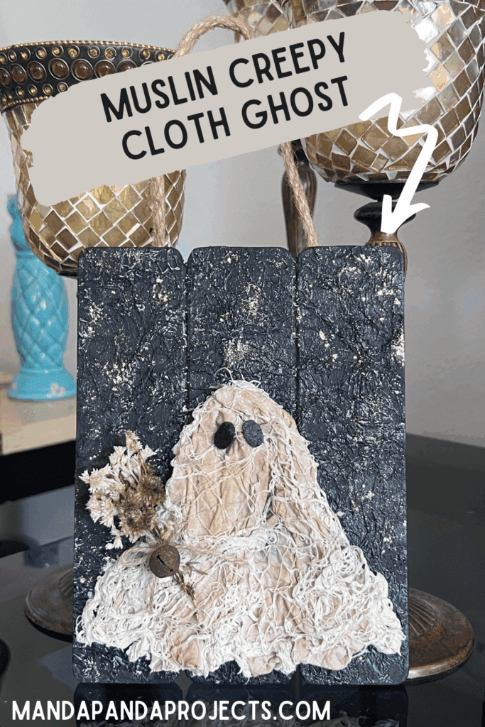 Coffee stained Muslin creepy cloth ghost holding a creme natural dried flower bouquet with a twine bow and rusty bell, with a black background with a gold starry night and a jute rope hanger.
