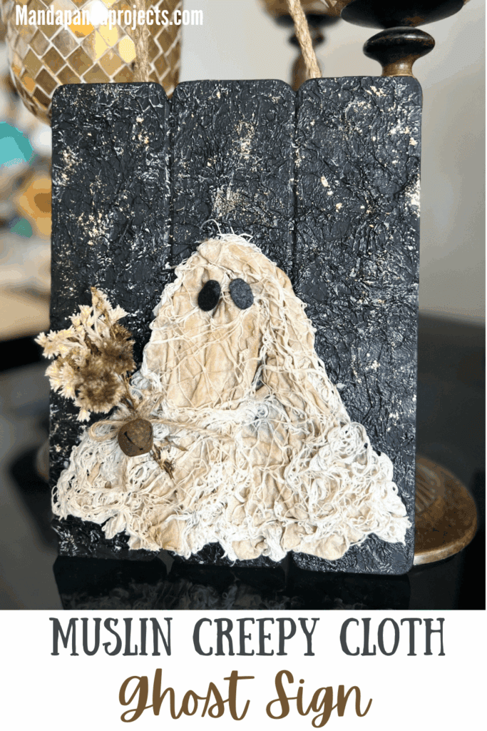 Coffee stained Muslin creepy cloth ghost holding a creme natural dried flower bouquet with a twine bow and rusty bell, with a black background with a gold starry night and a jute rope hanger.