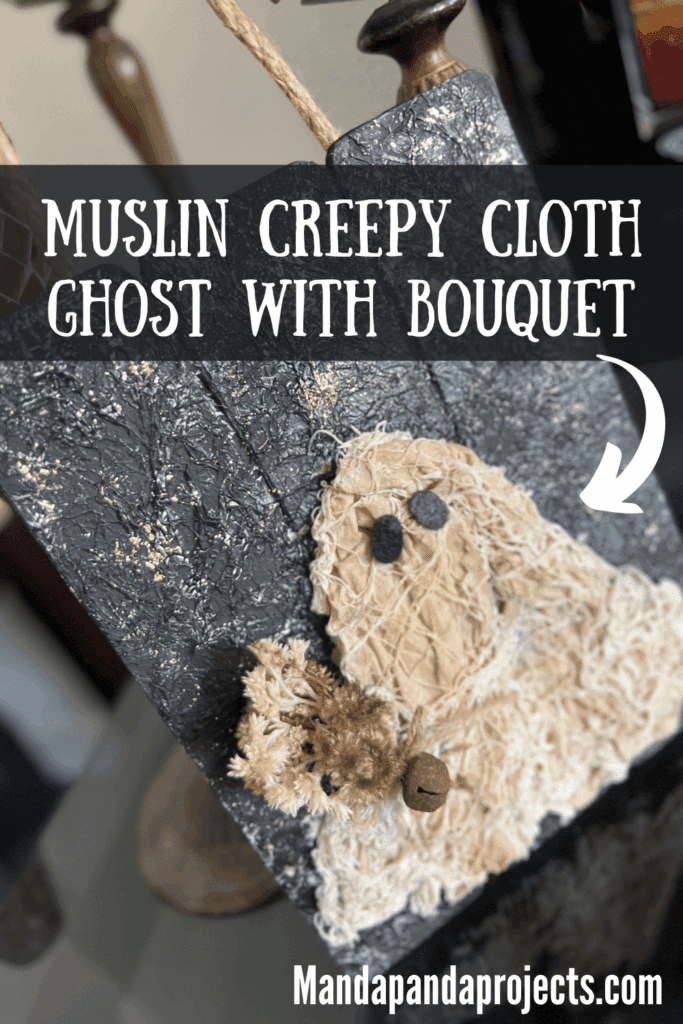 Coffee stained Muslin creepy cloth ghost holding a creme natural dried flower bouquet with a twine bow and rusty bell, with a black background with a gold starry night and a jute rope hanger.