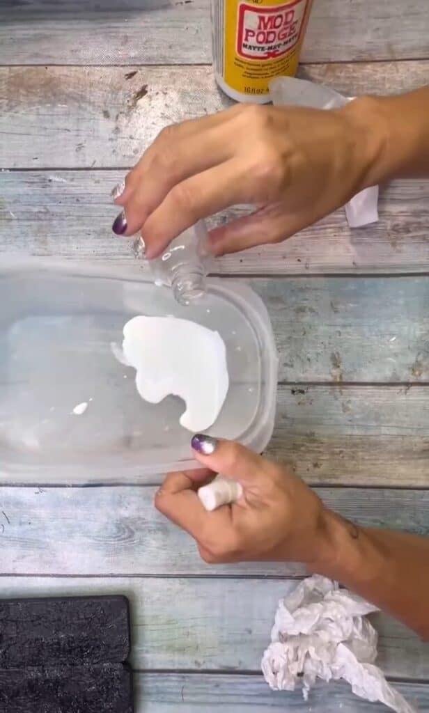 Mixing together some Mod Podge and water in a bowl.