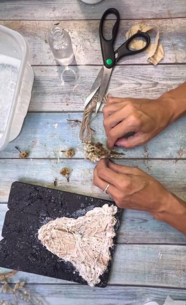 Making a miniature dried flower bouquet by taking some creme dried florals and tying a piece of twine around the stems.