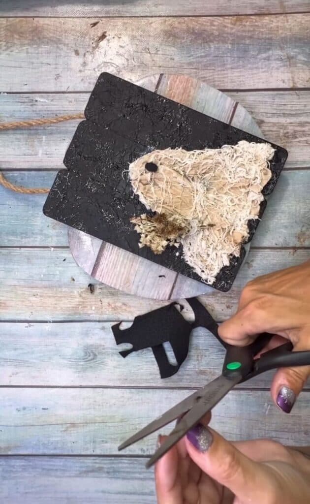 Cutting two ovals out of black felt.