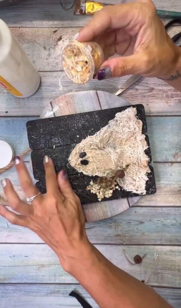 Rub gold leaf foil onto the blacl background.