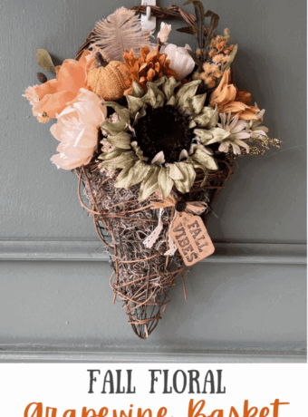 Fall floral grapevine wreath basket door decor hanging on a sage green front door with pretty fall flowers, a sweater pumpkin pick and a hangtag that says "Fall vibes".