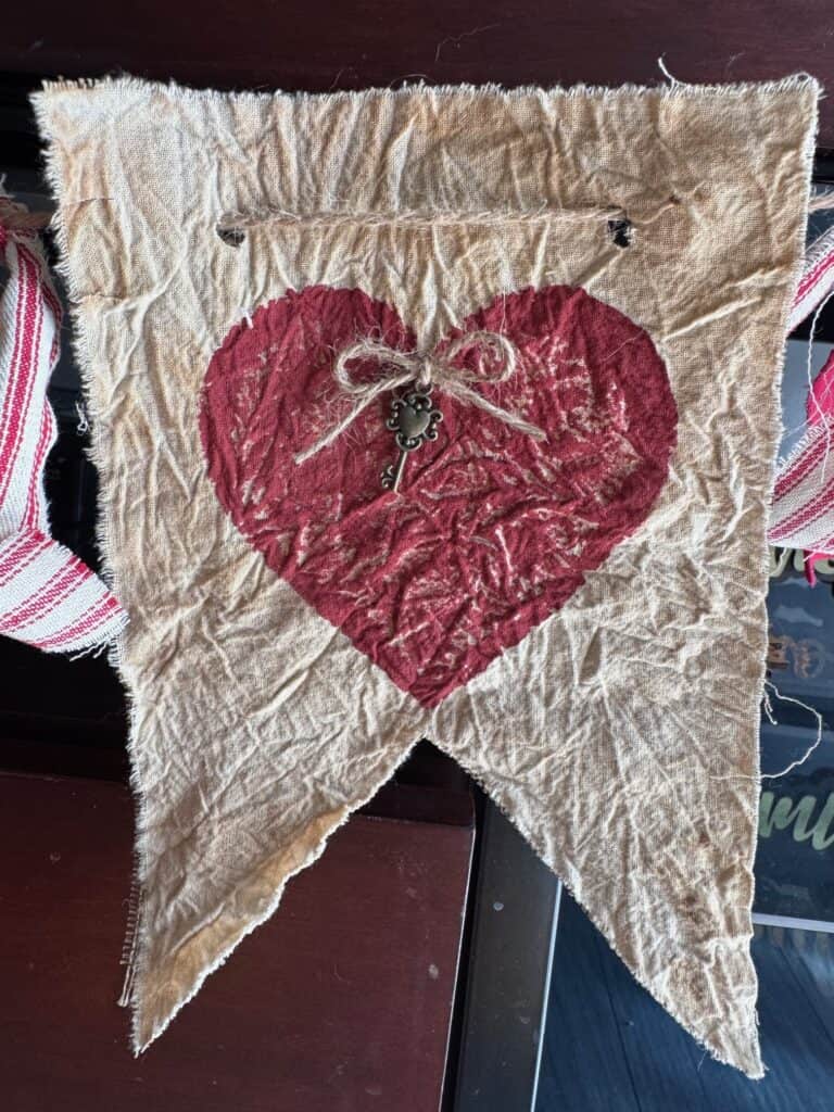 The pendant of the banner with coffee stained muslin and a deep red heart.
