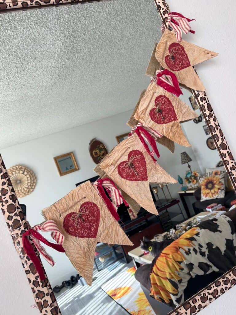 Primitive Style Valentines Day Heart Garland or banner with coffee stained muslin, deep red hearts, skeleton key embellishments and red homespun fabric DIY Decor hanging on a mirror.