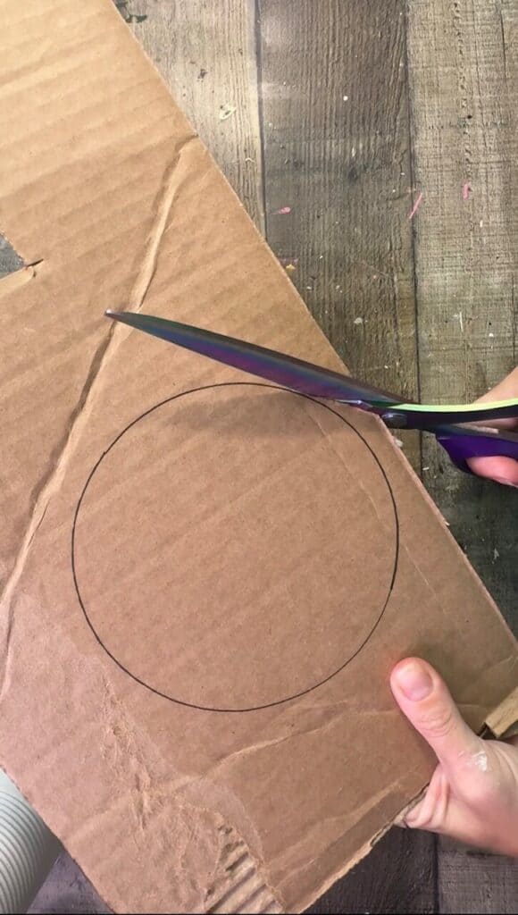 Cutting a cardboard circle out.