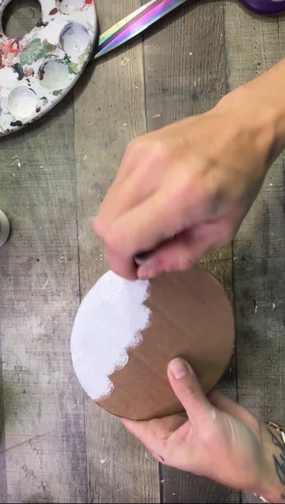 Painting the cardboard circle white with a spouncer.