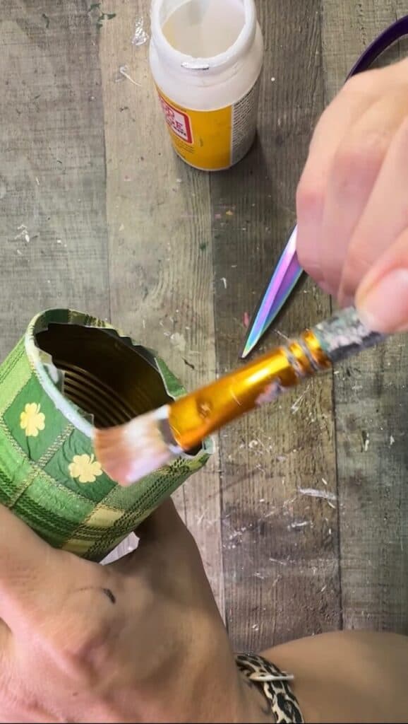 Mod Podging the excess napkin around the bottom of the tin can.
