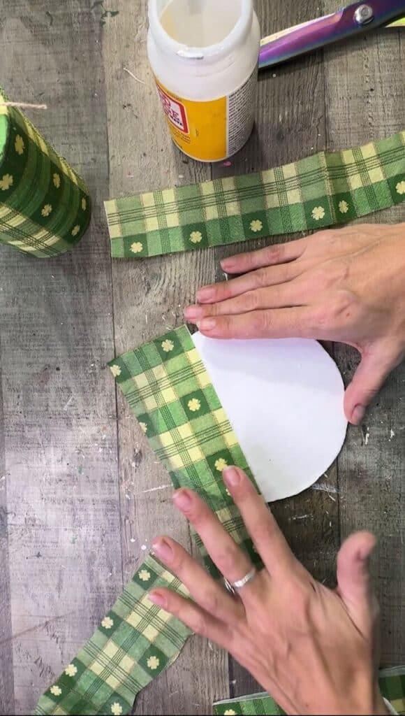 Decoupaging the green check napkin to the cardboard brim.