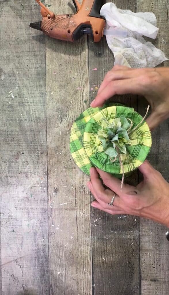 Gluing the tin can to the brim of the hat.