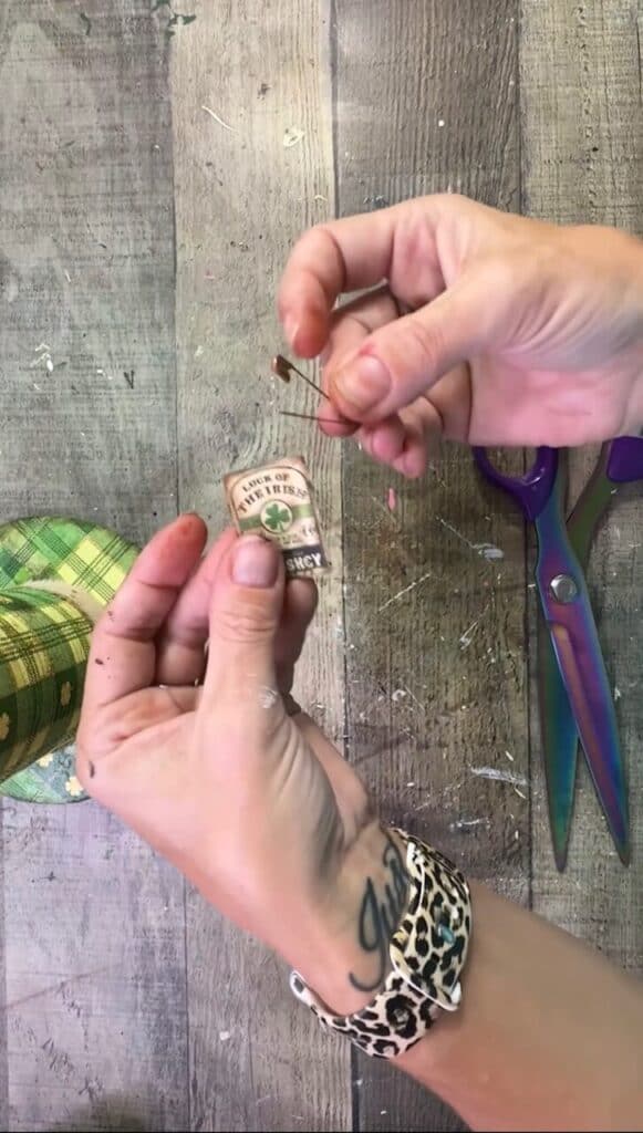 An irish hangtag with a Gogle image and a rusty safety pin.