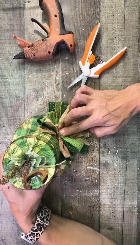 Gluing the bow to the brim of the leprechaun hat.